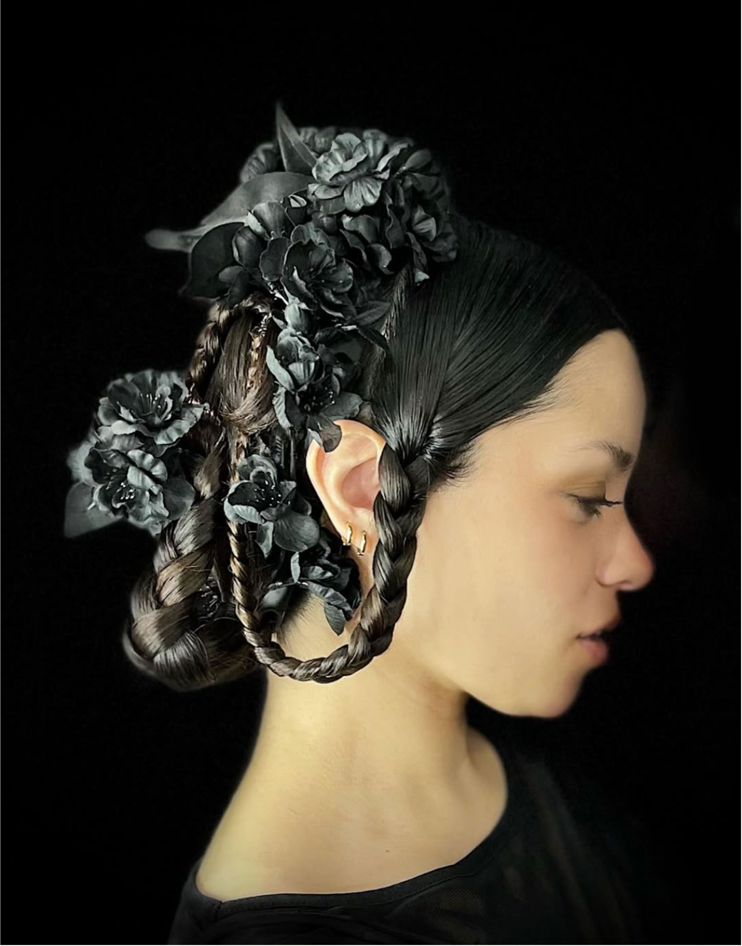 Editorial updo with braided detail and a black floral headpiece.