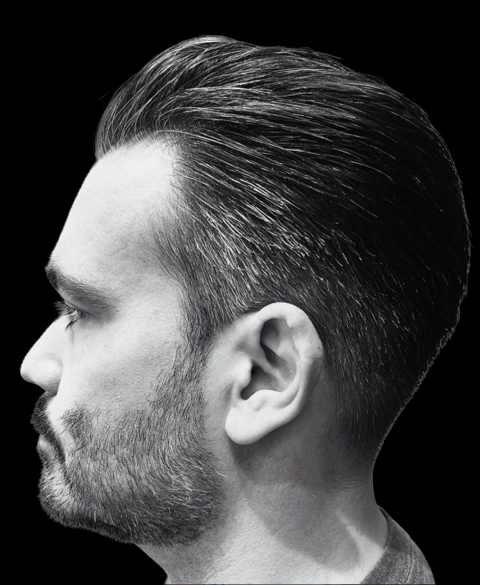 Slicked-back men’s cut, black-and-white profile.