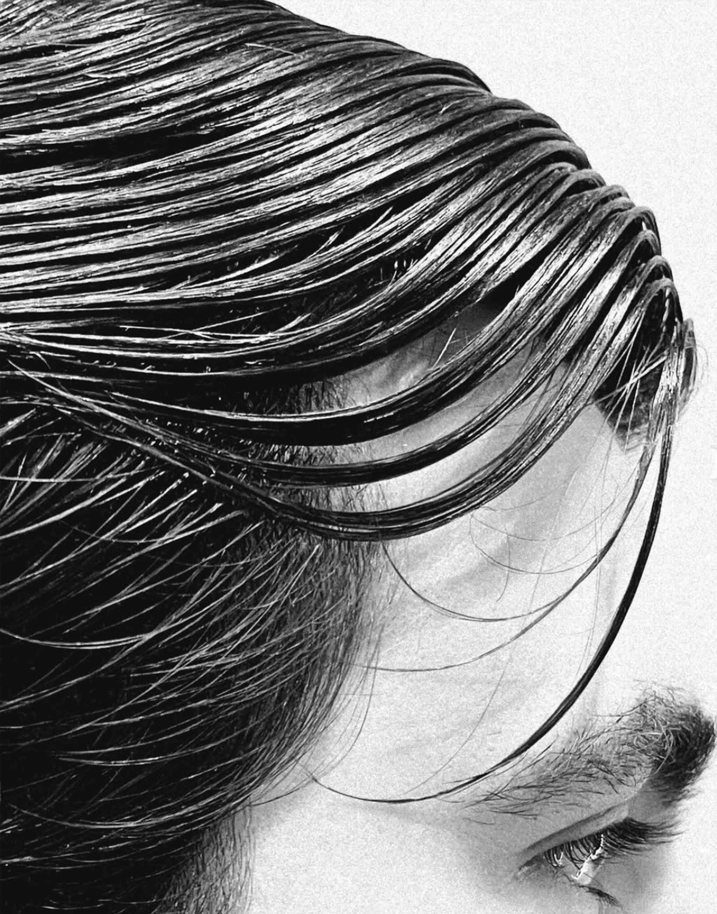 Wet-look slicked men’s style, profile view.