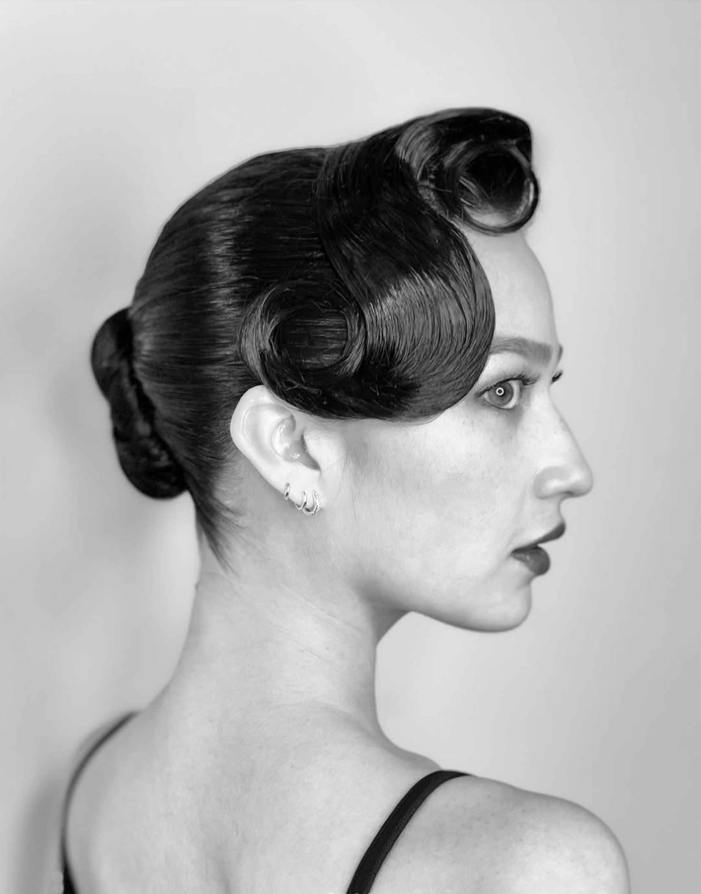 Sculpted vintage-wave updo, black-and-white profile.
