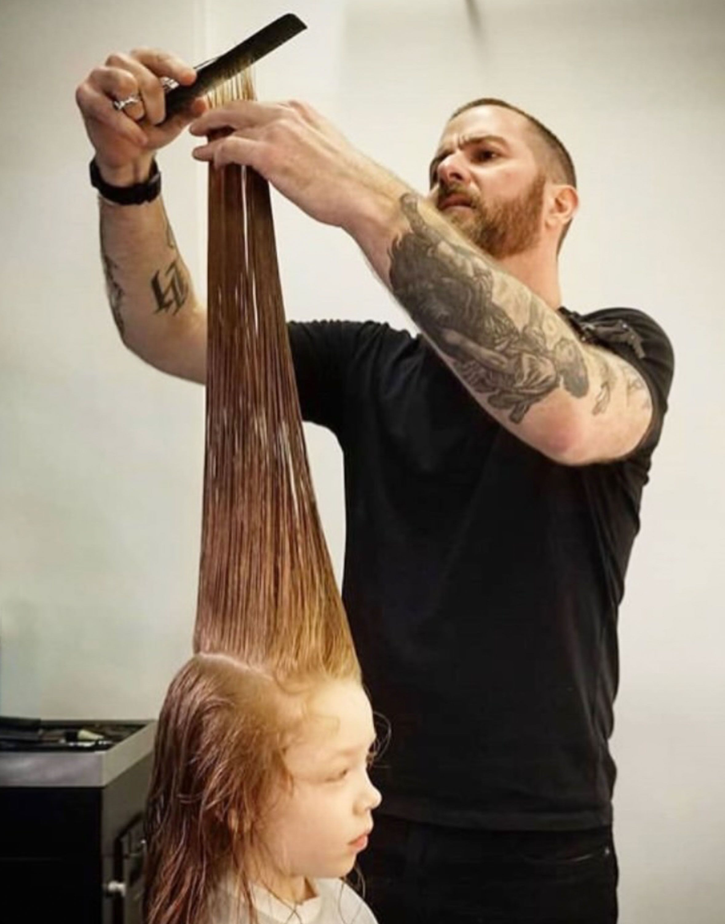 David sectioning long hair mid-cut at the salon.
